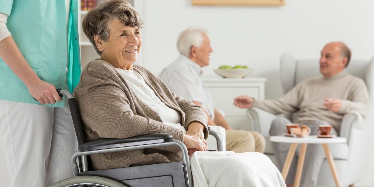 A woman in a wheelchair sitting next to two other people.